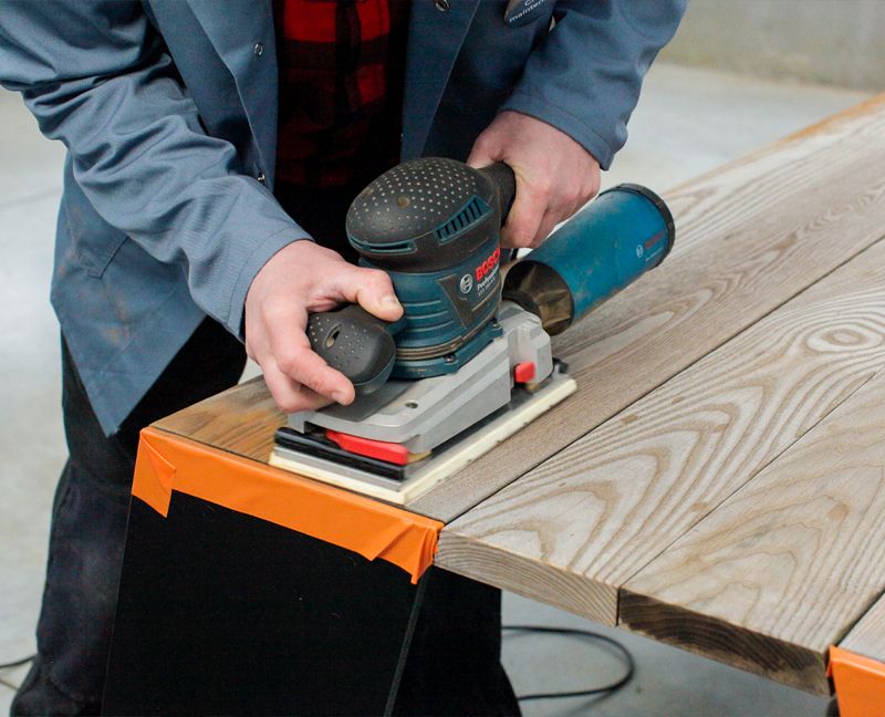 Machine sanding wooden outdoor furniture